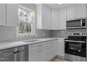 Modern kitchen with white cabinetry, stainless steel appliances, and a bright window at 100 Royall Rd, Oxford, NC 27565