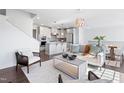 Open-concept living room and kitchen with hardwood floors, modern furniture, and stainless steel appliances at 10210 Sablewood Drive # 112, Raleigh, NC 27617