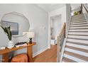 Bright foyer featuring wood floors, modern mirror, console table, and staircase with a wood banister at 1028 Zelkova Ln, Chapel Hill, NC 27517