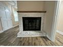 Stylish whitewashed brick fireplace with a wooden mantel at 103 Beam Cir, Louisburg, NC 27549