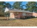 A cozy brick home showcases an inviting carport and a well-maintained yard at 1101 Nashville Rd, Rocky Mount, NC 27803