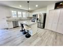 Modern kitchen with a center island, stainless steel appliances, white cabinetry, and wood floors at 112 Wichita Way, Louisburg, NC 27549