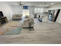 Bright, open-concept living area featuring wood floors and a modern kitchen with stainless steel appliances at 112 Wichita Way, Louisburg, NC 27549