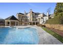 Luxury home with a large backyard pool, spa, and a covered outdoor kitchen area at 1404 Barony Lake Way, Raleigh, NC 27614