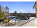 Balcony view overlooking the backyard pool, spa, and a peaceful lake surrounded by mature trees at 1404 Barony Lake Way, Raleigh, NC 27614