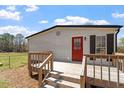 A cozy back deck offers a great space for outdoor entertaining, with a quaint red back door at 1425 Country Pond Ln, Willow Springs, NC 27592