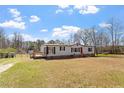 Single-story home with a well-manicured front yard, complete with a deck, perfect for outdoor enjoyment at 1425 Country Pond Ln, Willow Springs, NC 27592