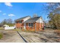 Angle view of a two-story red brick house with a spacious front yard at 1506 N Mebane St, Burlington, NC 27217