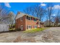 A two-story brick house features classic architecture and a neat landscape at 1506 N Mebane St, Burlington, NC 27217