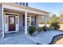 Inviting front porch with a stylish entry door and charming stone accents at 1613 Osprey Ridge Dr, Willow Springs, NC 27592