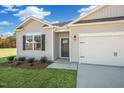 Inviting single-story home with gray siding, a two-car garage, and a well-maintained lawn at 195 Hawksmoore Ln, Lillington, NC 27546
