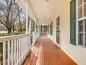Spacious front porch with stained wood floor and white railings, perfect for relaxing outside at 204 Sugarland Dr, Apex, NC 27502