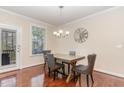 Cozy dining room with hardwood floors, chandelier lighting, and view to the backyard at 2418 Pecan Ridge Way, Apex, NC 27502