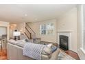 Bright living room featuring hardwood floors, a cozy fireplace, and a staircase at 2418 Pecan Ridge Way, Apex, NC 27502
