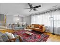 Bright living room with a large window, staircase, hardwood floors, and a decorative rug at 256 Marilyn Cir, Cary, NC 27513