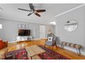 Well-lit living room with hardwood floors, ceiling fan, TV, and stylish decor at 256 Marilyn Cir, Cary, NC 27513