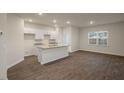 Bright, open-concept kitchen featuring white cabinets and a granite countertop island at 261 Canopy Dr, Graham, NC 27253