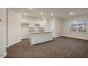 Bright, open-concept kitchen featuring white cabinets and a granite countertop island at 261 Canopy Dr, Graham, NC 27253