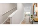 Bright hallway leading to a living area with wood floors, and stairs with white railings at 267 Canopy Dr, Graham, NC 27253