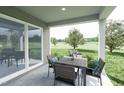 Covered patio area, perfect for outdoor dining, features wood furnishings and a serene view of the backyard at 27 Artesa Ct, Fuquay Varina, NC 27526