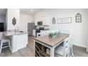 Modern kitchen featuring white cabinets, stainless steel appliances, and a dining area at 31 Harrow Ter, Roxboro, NC 27574