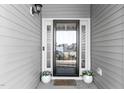 Close-up of front door with decorative plants and a 'welcome' mat, creating a warm and inviting entry at 3541 Fairstone Rd, Wake Forest, NC 27587