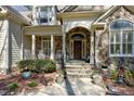 Stunning front entrance with stone accents, a covered porch, and meticulously landscaped surroundings at 3655 Pleasants Ridge Dr, Wake Forest, NC 27587