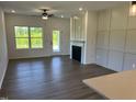 Bright living room with fireplace, modern ceiling fan, and plenty of natural light at 380 Pecan Valley Way, Four Oaks, NC 27524