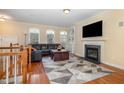 Living room has a fireplace, hardwood floors, large TV and large windows bringing in plenty of light at 4020 Abbey Park Way, Raleigh, NC 27612