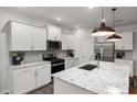 Bright kitchen with white cabinets, stainless steel appliances, and a large granite island with sink at 408 Providence Spring Ln, Fuquay Varina, NC 27526