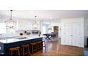 Bright kitchen with white cabinets, island with seating, and hardwood floors at 48 Blue Heron Ln, Roxboro, NC 27574