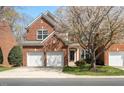 Attractive red brick two-story home with two-car garage and blossoming tree at 5036 Isabella Cannon Dr, Raleigh, NC 27612