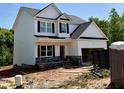 A two-story house with white siding, black shutters, a covered porch, and stone accents at 60 Moonraker Dr, Spring Hope, NC 27882