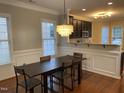Open dining area with stylish chandelier lighting, leading into a modern kitchen at 6002 River Estates Dr, Knightdale, NC 27545