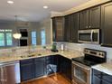Modern kitchen featuring dark cabinetry, granite countertops, and stainless steel appliances at 6002 River Estates Dr, Knightdale, NC 27545