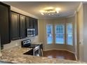 Bright kitchen featuring granite countertops, stainless appliances, and a breakfast nook with large windows at 6002 River Estates Dr, Knightdale, NC 27545