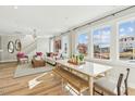 Bright, open-concept living and dining area with large windows, modern furnishings, and wood floors at 607 Callan View Ave, Wake Forest, NC 27587