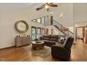 Spacious living room with wood floors, high ceilings, a modern sofa, and staircase access to the upper level at 6160 Virgilina Rd, Roxboro, NC 27574