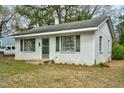 Charming one-story home with white brick, green shutters, and mature trees at 740 Long Ave, Rocky Mount, NC 27801