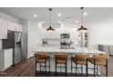 Modern kitchen featuring a large island with barstool seating, stainless steel appliances, and stylish pendant lighting at 744 Ben Ledi Ct, Raleigh, NC 27603