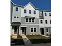 New construction townhome with gray siding, black windows, and professionally landscaped yard at 802 Hillfarm Dr, Wake Forest, NC 27587