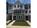 Charming three-story townhome featuring a modern color scheme and well-manicured landscaping at 802 Hillfarm Dr, Wake Forest, NC 27587