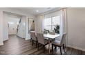 Cozy dining room with a wood table, upholstered chairs, a large window, and hardwood flooring at 1003 Red Roses Ave, Durham, NC 27703