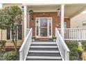 Inviting front porch featuring brick accents, a white railing, and a welcoming entrance at 102 Switchback St, Knightdale, NC 27545