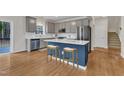 Well-lit kitchen featuring stainless steel appliances, an island with seating, and hardwood flooring at 102 Switchback St, Knightdale, NC 27545