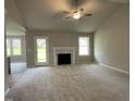 Bright living room with a fireplace, high ceilings, neutral carpet, and access to the backyard at 103 Oakfield Trace Dr, Four Oaks, NC 27524