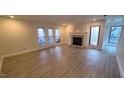 Open living room with modern floors, fireplace, and sliding glass doors leading to outdoor seating at 12 Melstone Turn, Durham, NC 27707