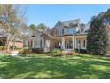 Charming two-story home boasts a manicured lawn and inviting front porch with detailed trim work at 1321 Colonial Club Rd, Wake Forest, NC 27587