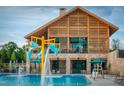 Beautiful community pool with water features and a clubhouse made of stone and timbers at 1524 Level Stream Rd, Wendell, NC 27591
