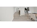 Bright hallway leading to a kitchen with white cabinets and stainless steel appliances and an adjacent dining area at 175 Gill Farm Way, Franklinton, NC 27525